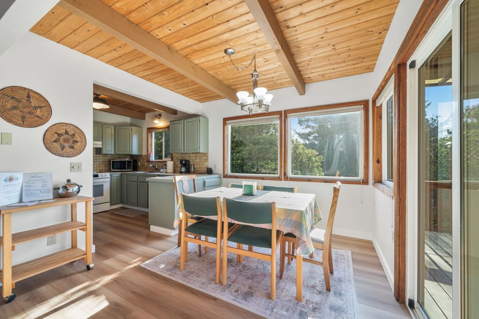 Dining area with access to deck with BBQ and outdoor seating.