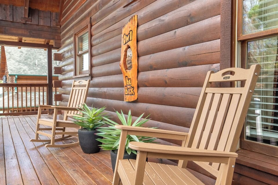 Settle into your rocking chair on this charming wooden deck, where rustic log cabin vibes and gentle greenery create the perfect spot to unwind.