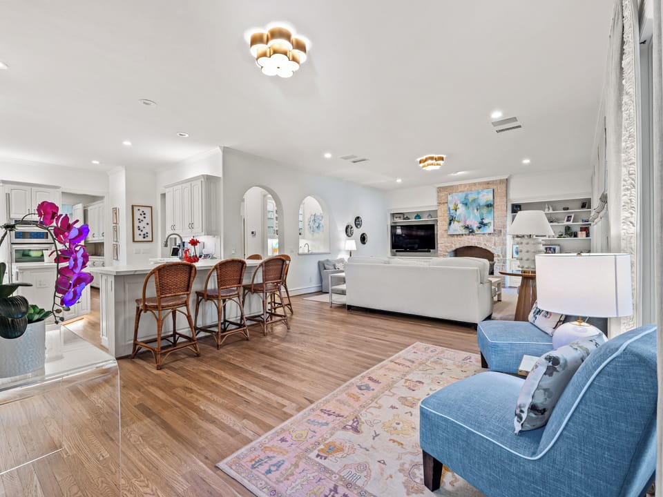 Relax in this bright, open living space where your kitchen flows seamlessly into comfortable seating areas with warm wood floors and modern style.