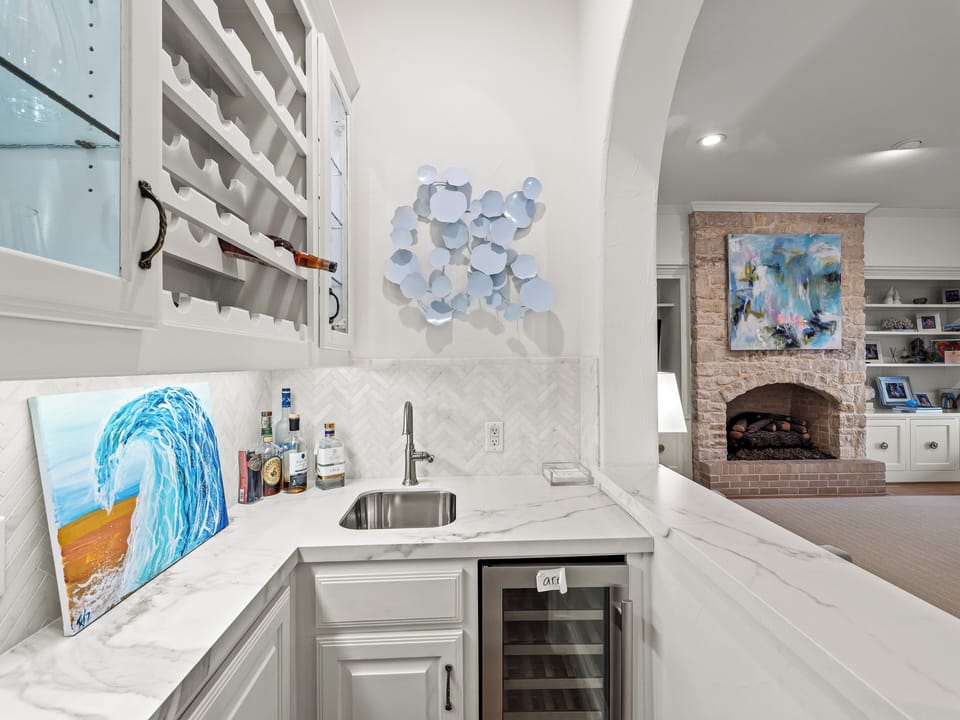 Your elegant wet bar features marble counters and wine storage, perfect for entertaining in your sophisticated living space.