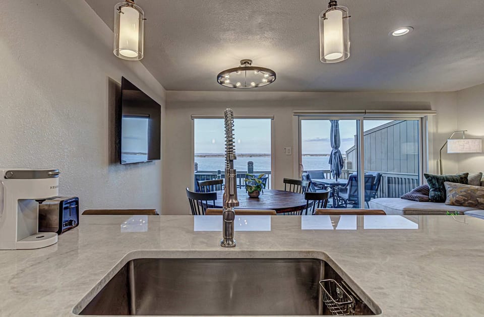 Modern kitchen with stainless appliances, breakfast bar seating, and open lake views.