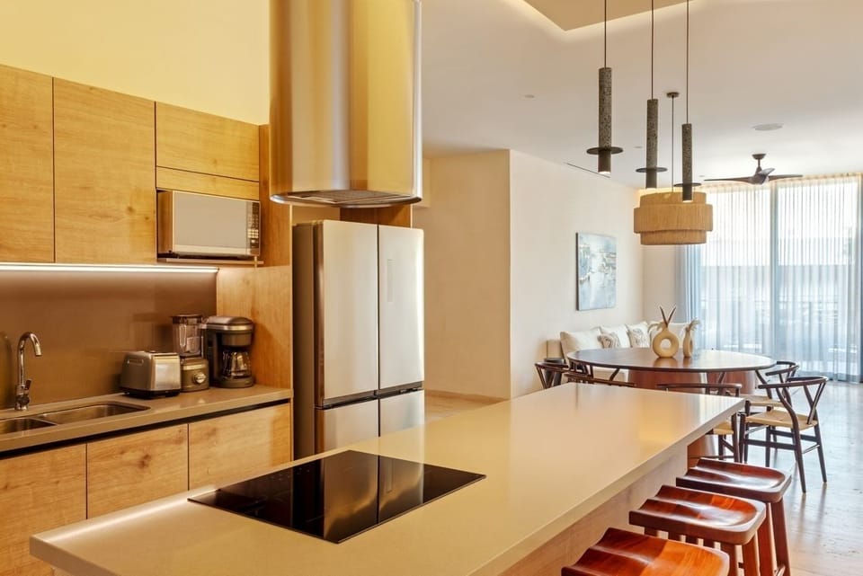 Host effortless meals beneath a statement chandelier and warm tones.
