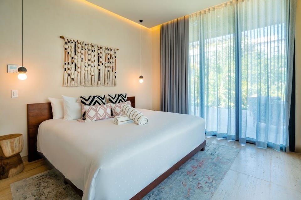 Sink into a cloud-soft bed beside sunlit, leafy views.