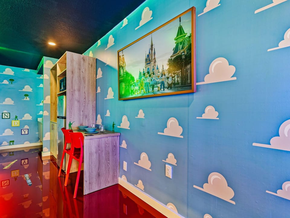 A playful kitchen nook with themed wall art and bright red chairs.