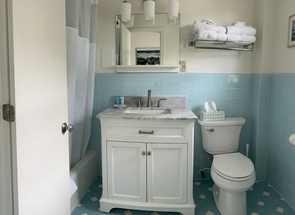 Bright vintage-style bathroom with blue tile and plush fresh towels