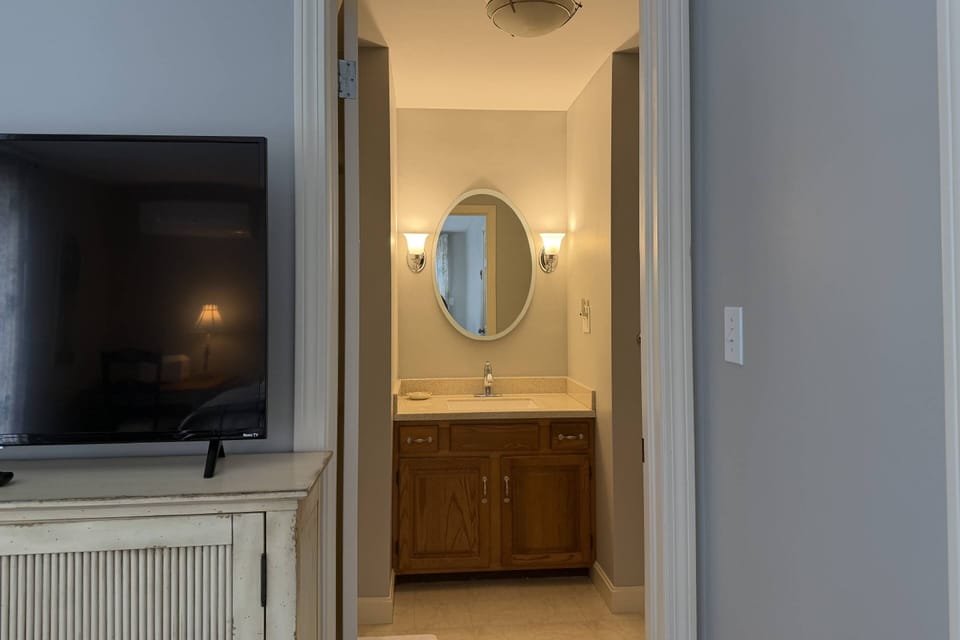 View from 1st floor bedroom with smartTV into full bathroom with standing shower