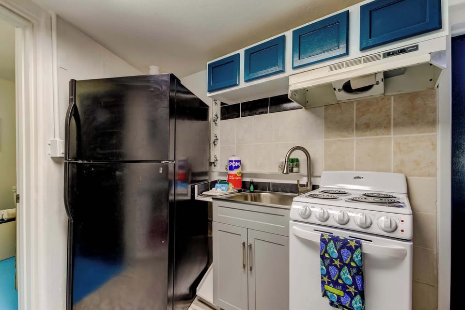 Kitchen with a refrigerator, sink, and stove, everything you need to prepare and enjoy home-cooked meals with ease.