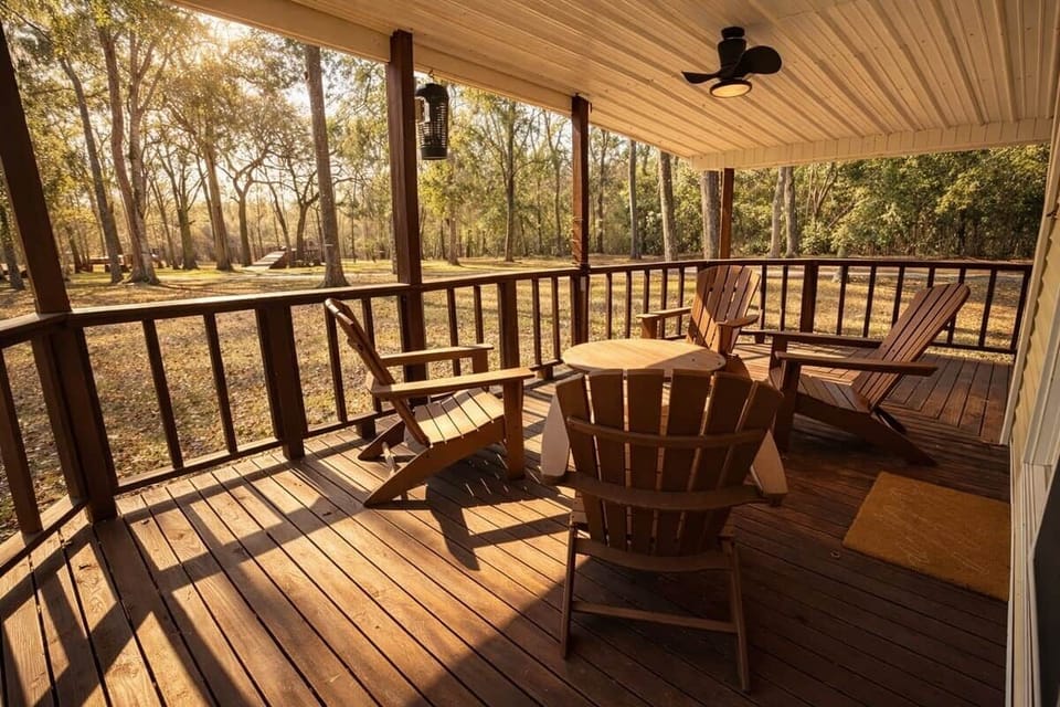 Step out from Bedroom 1 onto a covered porch with Adirondack seating—perfect for morning coffee or winding down at sunset. Surrounded by trees and peaceful views, it’s an easy spot to relax and enjoy the fresh air.