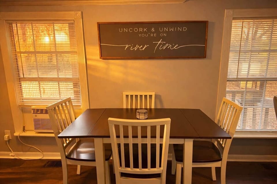 Gather for meals in a warm, sunlit dining area with a comfortable table and seating for four. Large windows fill the space with natural light, creating an inviting spot for breakfast, game night, or planning your next adventure.