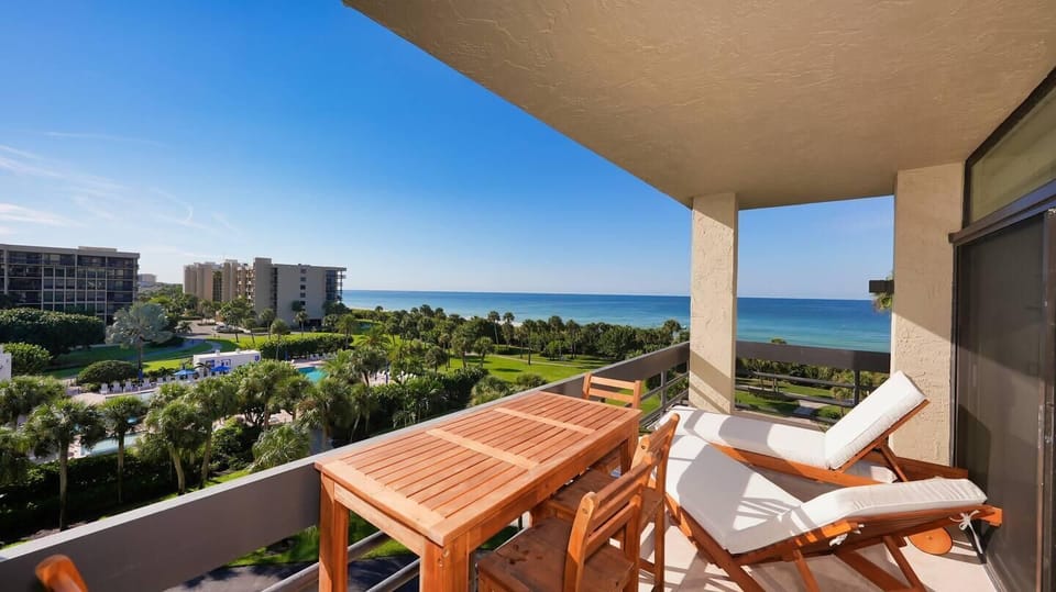Sunlit balcony with ocean views and cozy seating