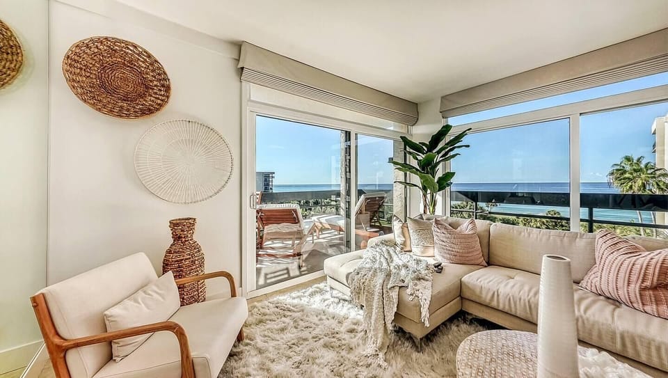 Sunlit living room with panoramic ocean views and cozy seating