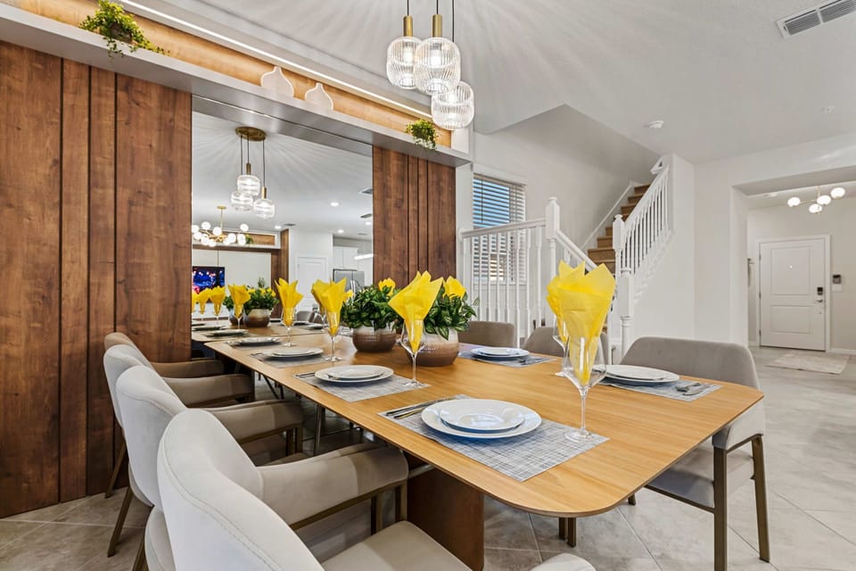 Spacious dining area with warm wood accents and a dramatic mirror wall-bright, modern, and ready for family feasts!