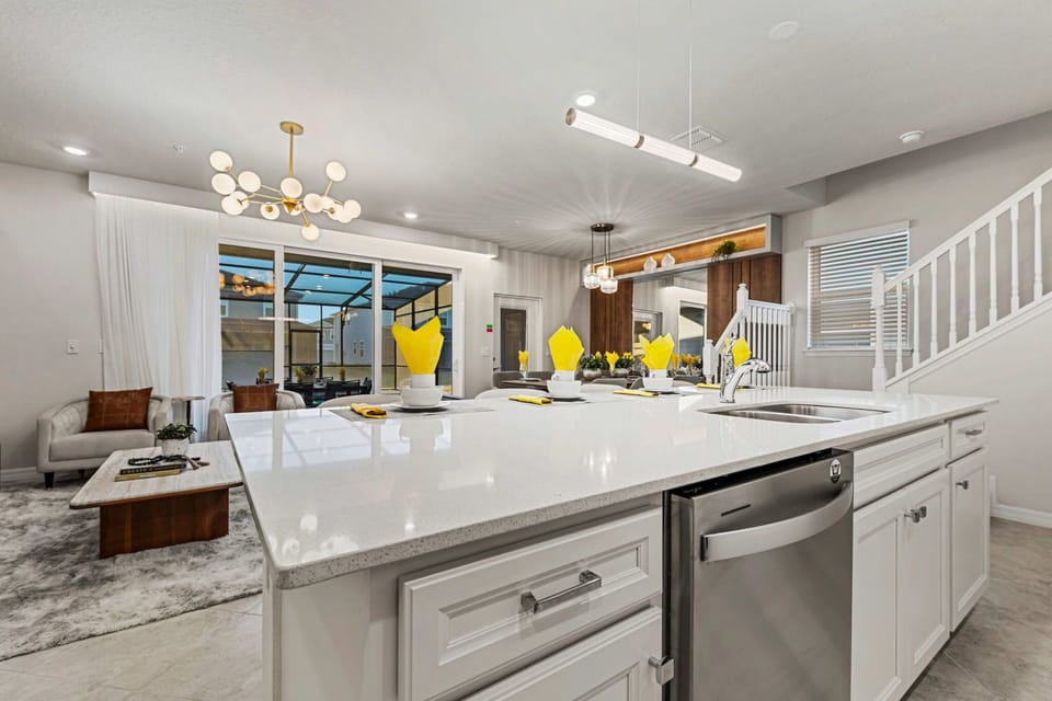 Open-concept living: gather at the oversized island (seating for four), enjoy chic pendant lighting, and slide open the doors to the screened patio-bright, modern, and social!