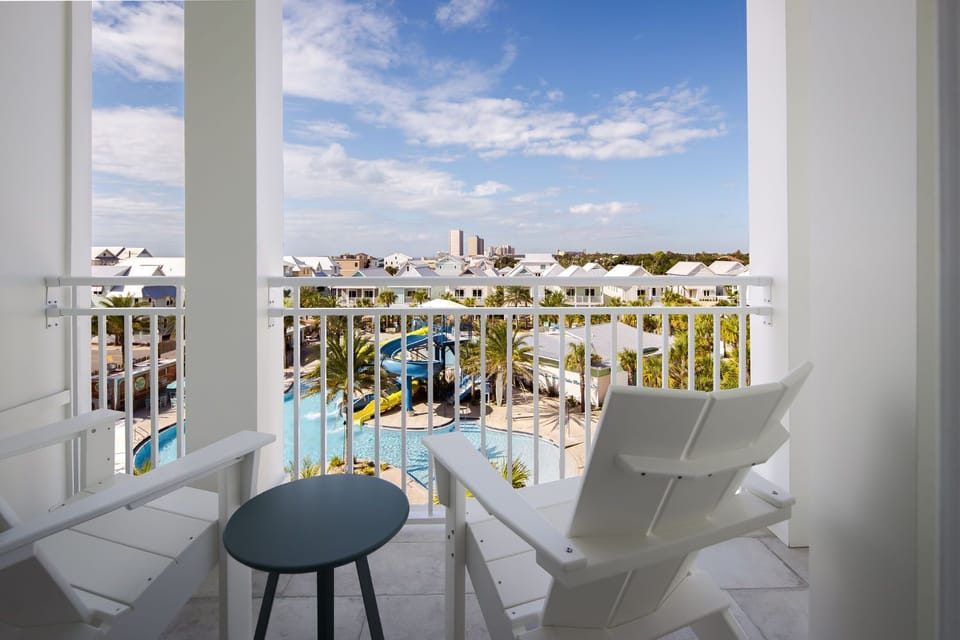 Enjoy the breathtaking Gulf views from a private balcony with minimalistic furniture, perfect for relaxation and leisure.