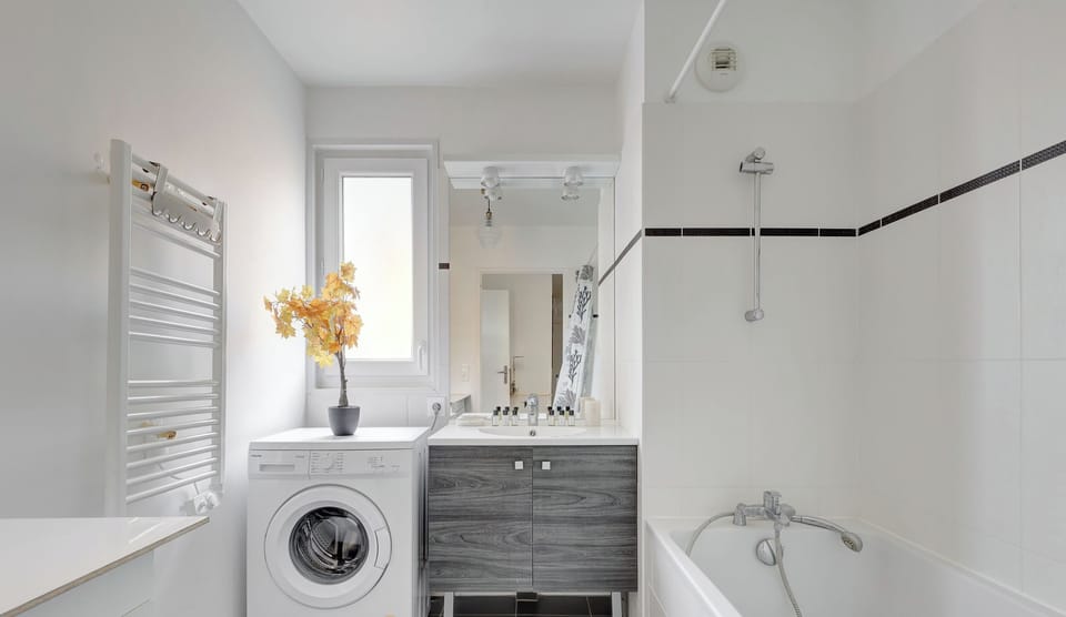 Salle de bain : douche, lave-linge, lavabo et toilette
