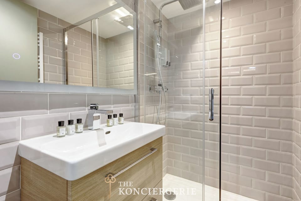 Salle de bain équipée avec miroir, douche, toilette