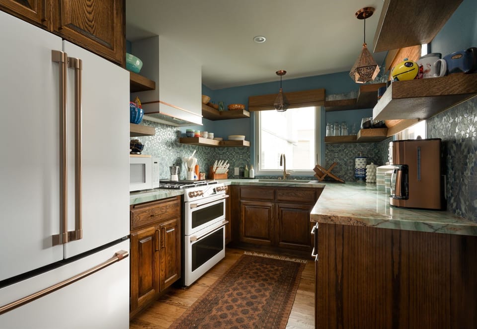A thoughtfully stocked kitchen with warm wood tones and open shelving, ready for everything from simple breakfasts to relaxed home-cooked meals.