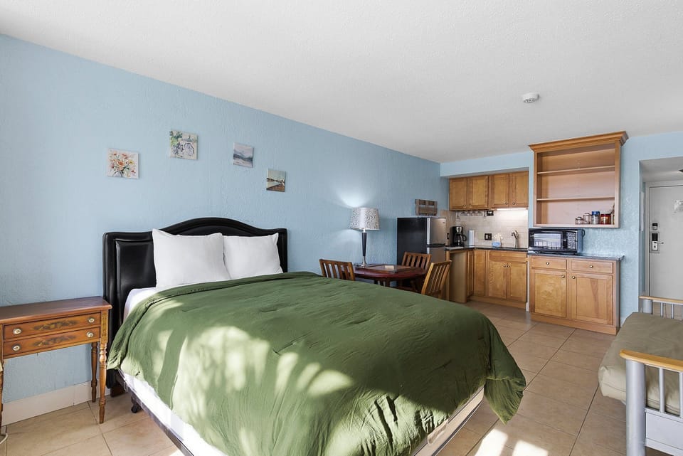Spacious beach stay studio featuring a plush queen bed, cozy dining area, and fully equipped kitchenette. Just steps from the beach, enjoy comfort and convenience for the perfect seaside getaway.