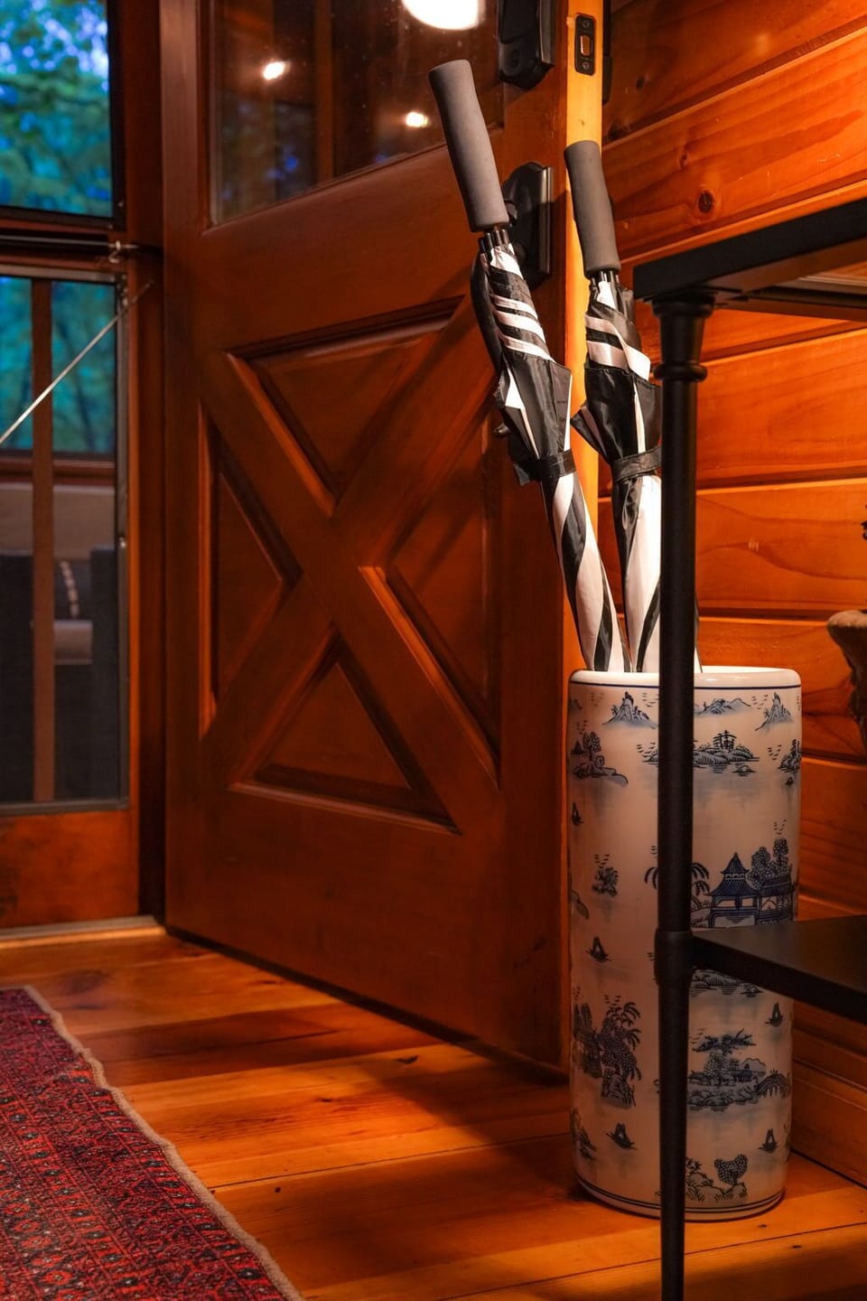Warm cabin entry with chic umbrella stand and cozy rug accents