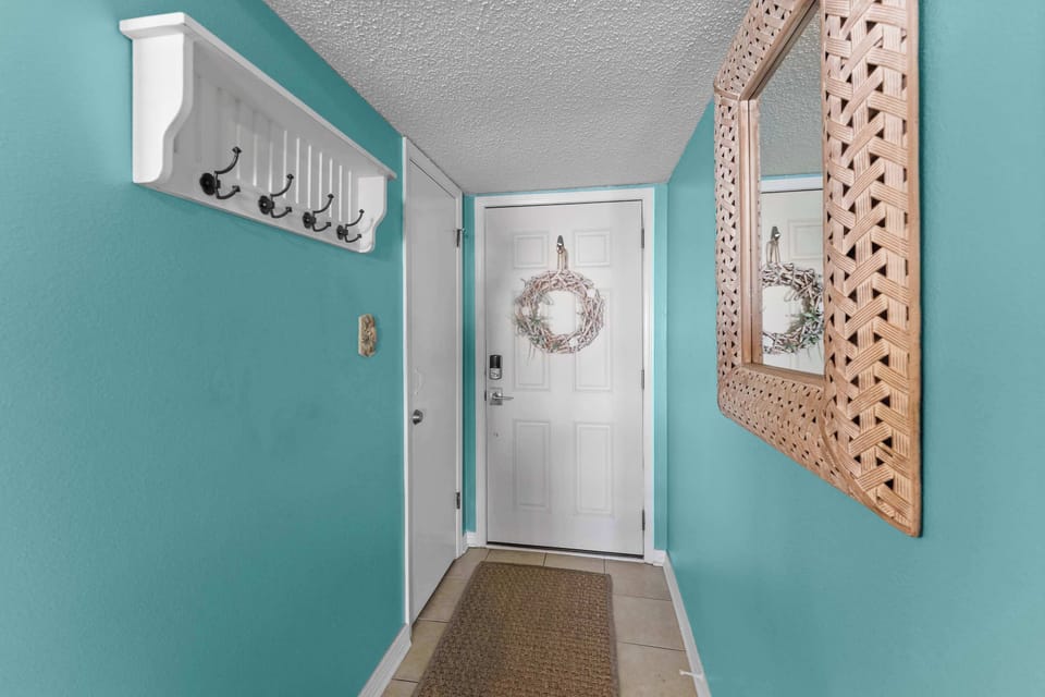 Interior entry hallway with keyless entry and convenient hooks for bags, hats, and beach gear.