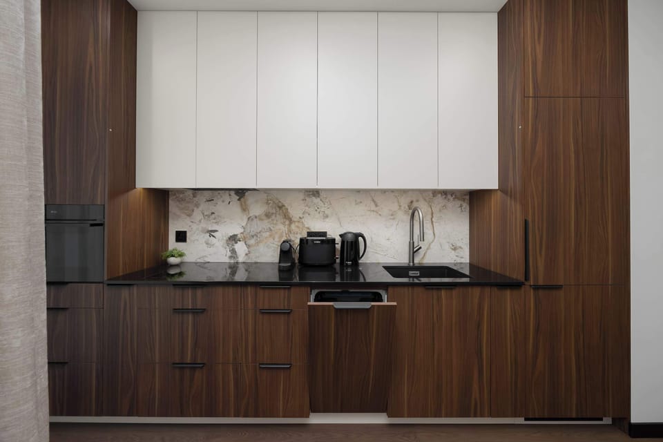 A kitchen with elegant furniture and a dishwasher, ensuring a comfortable stay.