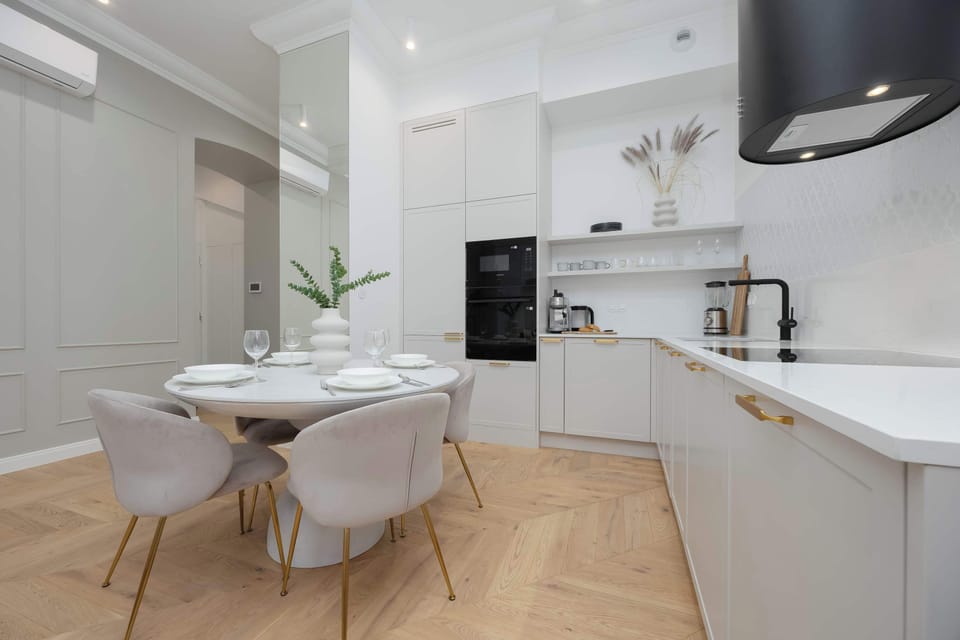 A minimalist kitchen with white cabinets and built-in appliances. The countertop is uncluttered and sleek. The space feels bright and practical.