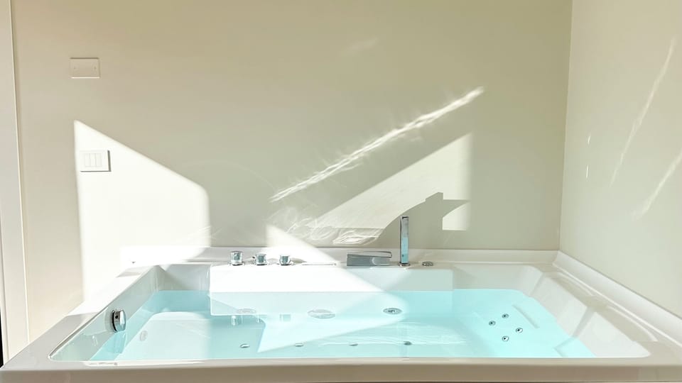 Luxury Studio Suite, 1 King Bed, City View | Bathroom | Free toiletries, hair dryer, slippers, towels