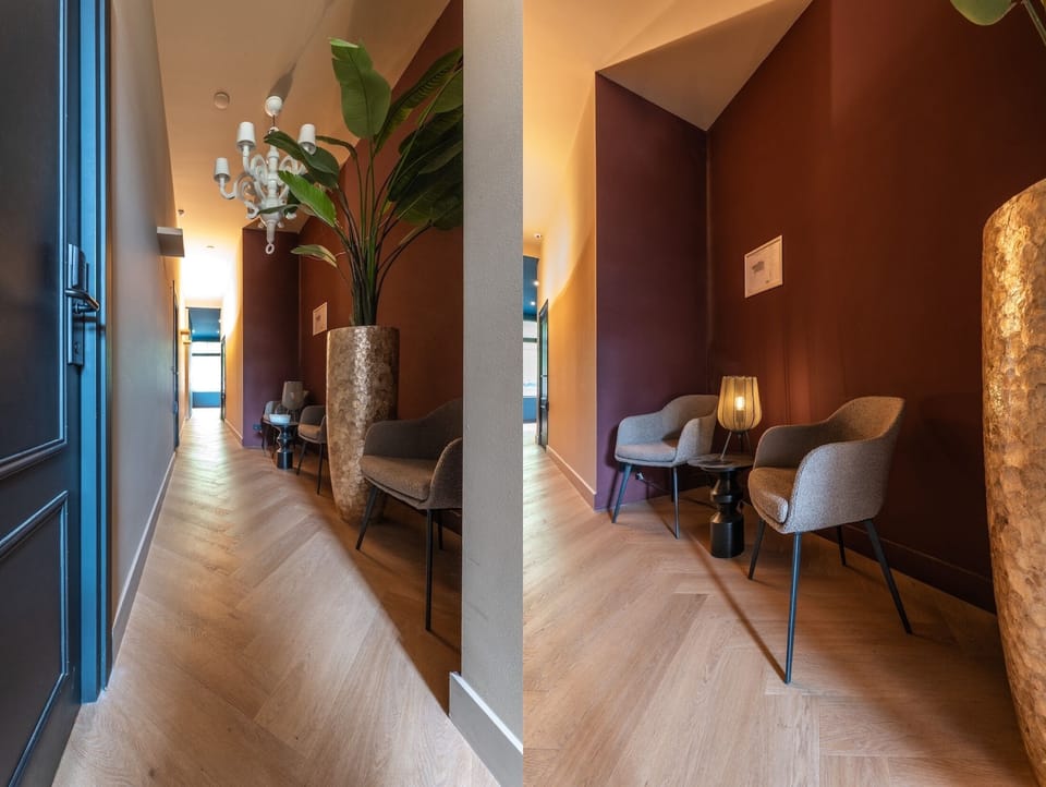 Relaxing seating area featuring modern armchairs, a side table, ambient lighting, and sophisticated interior design.
