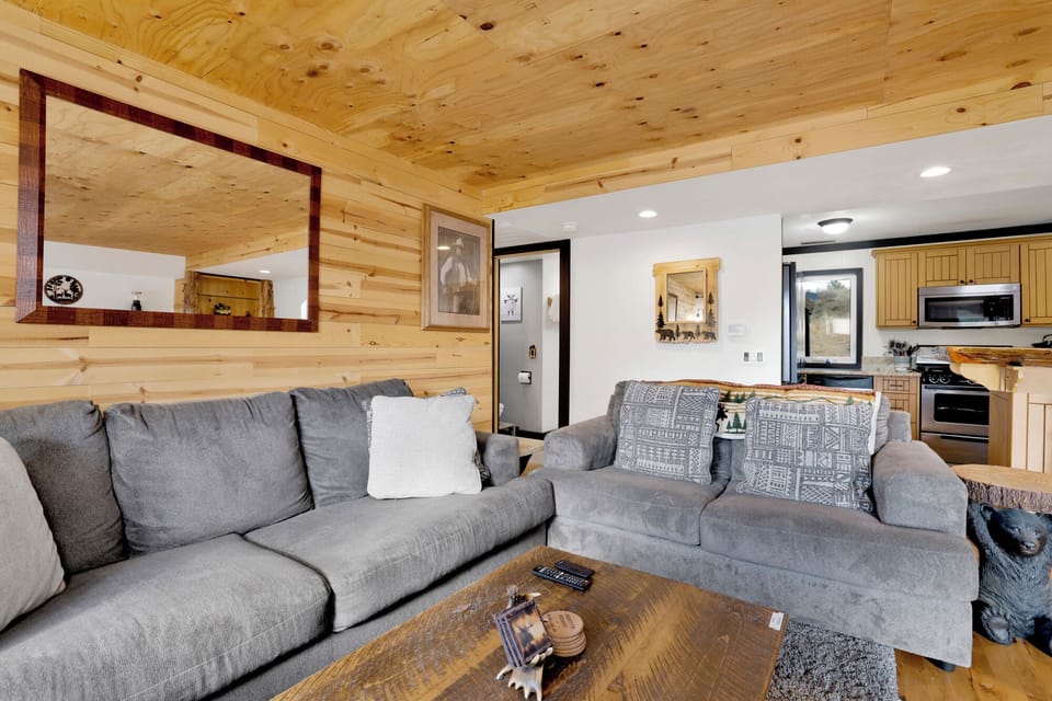 Cozy mountain living room with a fireplace, comfy seating, and smart TV—perfect for relaxing evenings, movie nights, and warm cabin vibes after outdoor adventures.