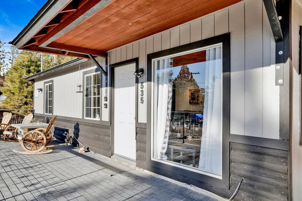 Welcoming cabin entry surrounded by towering pine trees, offering fresh mountain air and a peaceful forest setting—the perfect first impression for your Big Bear Lake getaway.