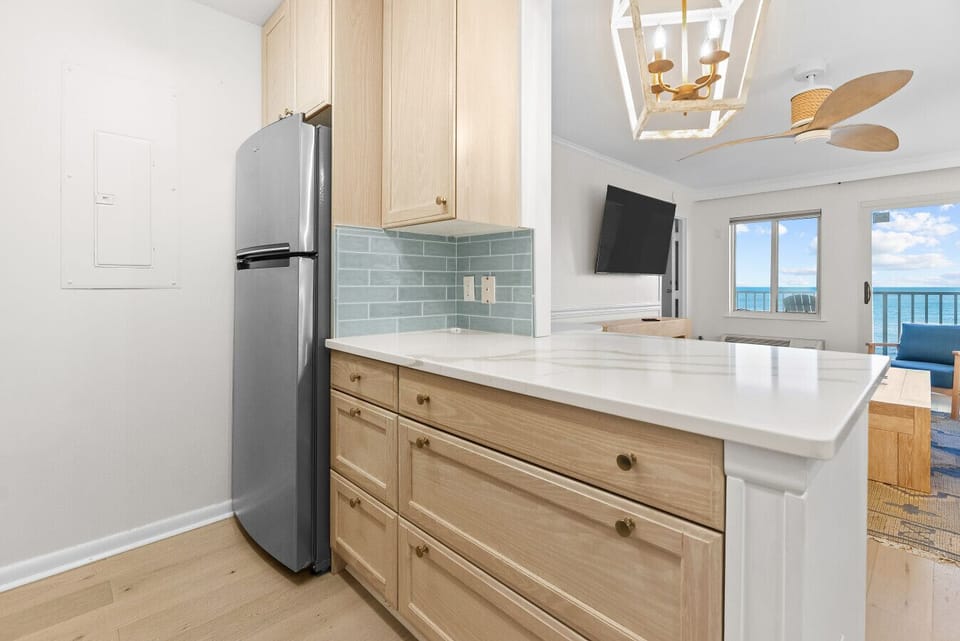 Bright kitchen island with ocean views just beyond.