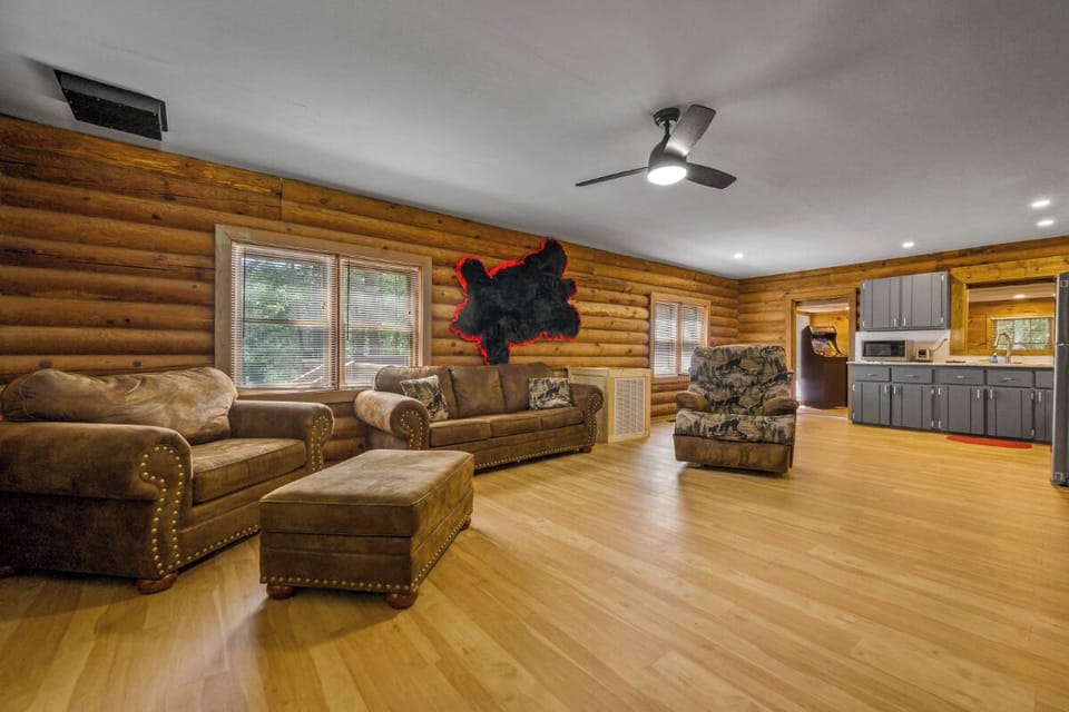 Relax in your spacious log cabin living room with rustic leather seating and modern kitchen convenience.