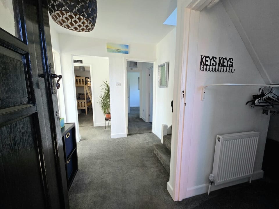 The ground-floor entrance hall offers direct access into the property, with a coat hook rail, hangers, a key rack and a radiator visible on entry.