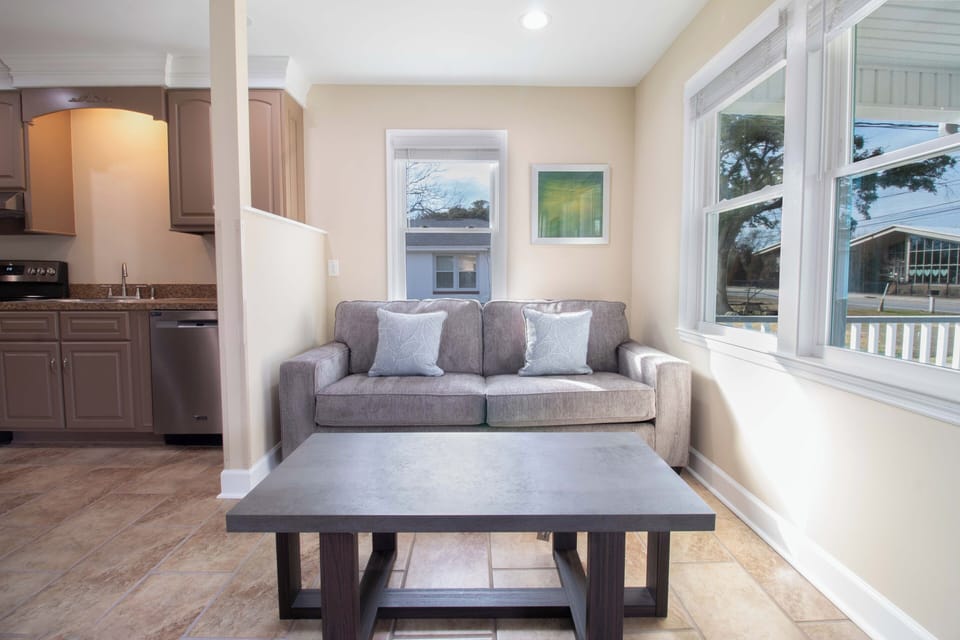 Sink into the plush sofa with morning coffee as natural light streams through large windows, creating your perfect retreat.