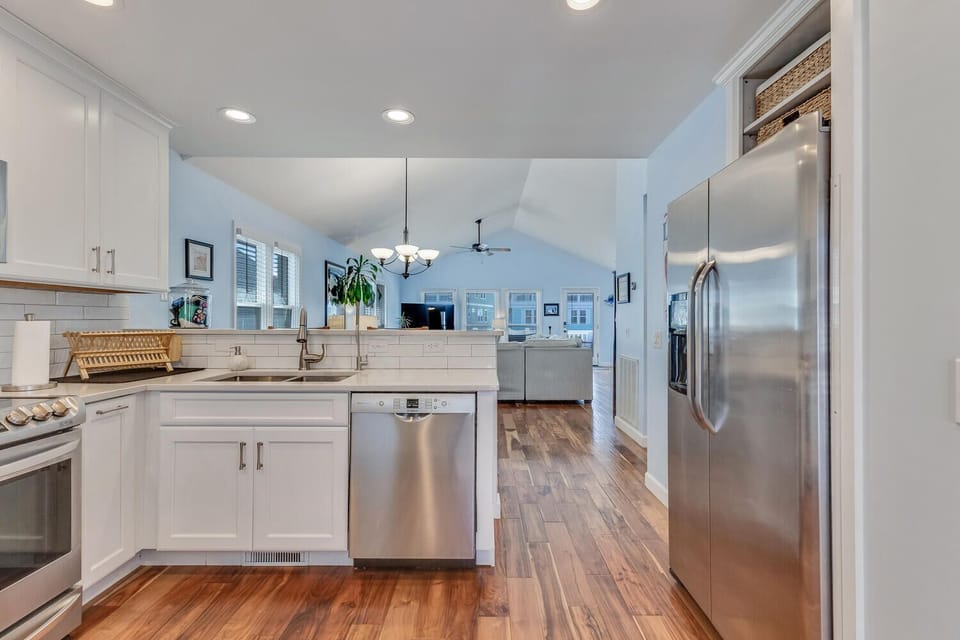 Your spacious kitchen features gleaming stainless steel appliances, crisp white cabinets, and warm hardwood floors perfect for home-cooked meals.