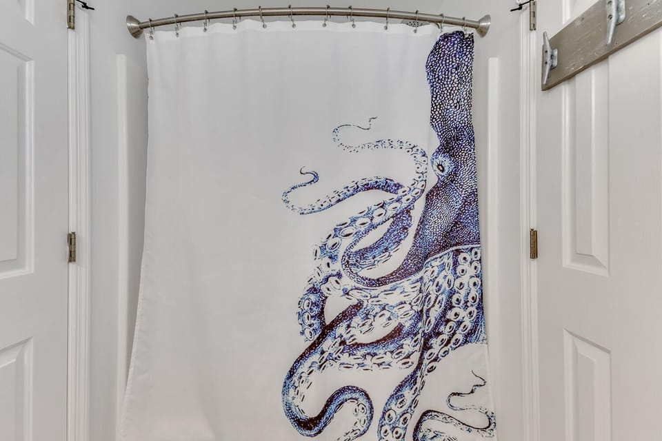 Your bathroom features artistic ocean-themed touches that make every shower feel like a coastal escape.