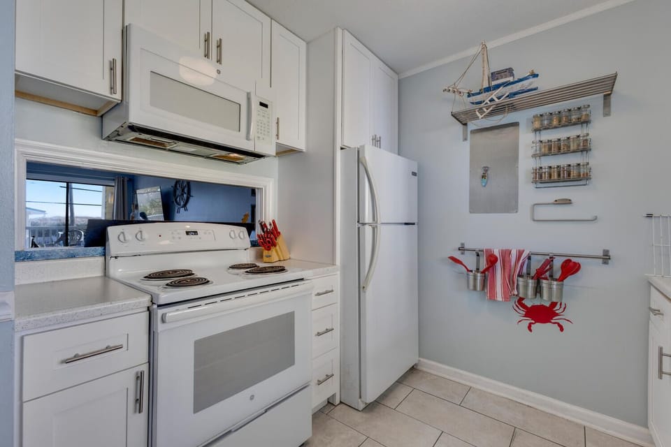 Your fully equipped kitchen awaits with modern appliances and charming nautical touches, perfect for preparing meals during your coastal getaway.