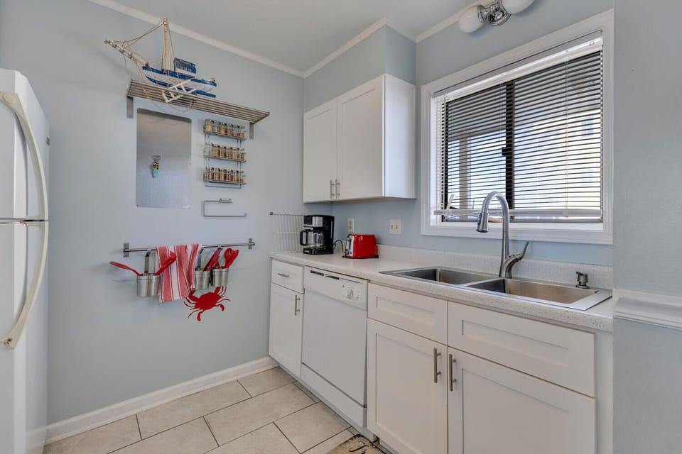 Your fully-equipped kitchen awaits with coastal charm and modern amenities, perfect for preparing meals during your seaside getaway.