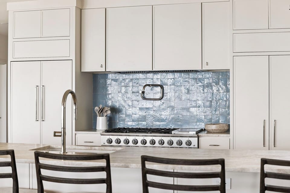 Cook your favorite meals in this elegant kitchen featuring gleaming countertops, premium appliances, and stunning backsplash.
