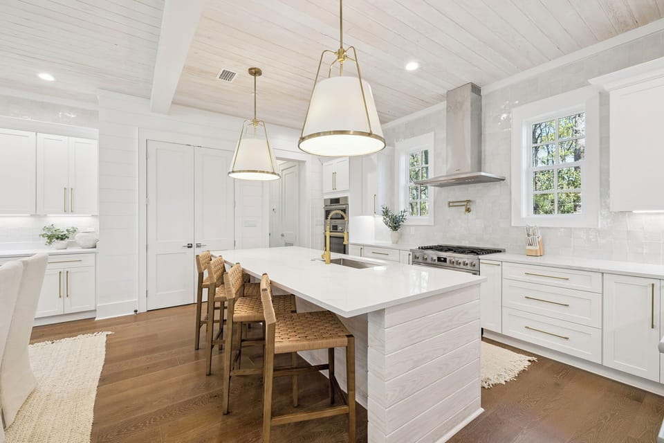 Cook memorable meals in your dream kitchen featuring pristine white cabinetry, gleaming countertops, and warm pendant lighting creating the perfect culinary haven.