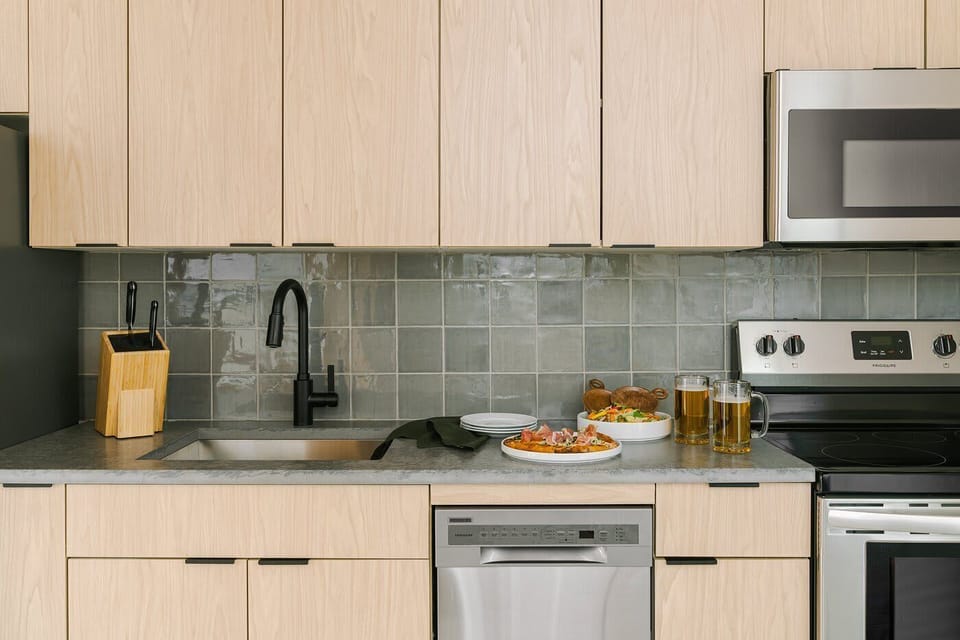 Modern kitchen with stovetop, oven, microwave, cookware, and dining essentials