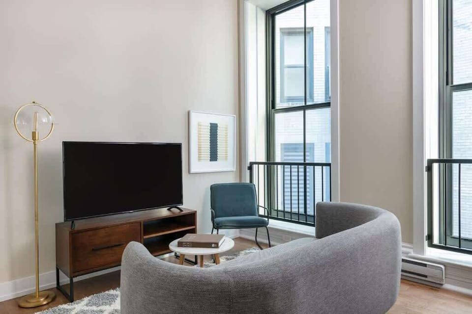 Bright Living Room with Natural Light
Open Concept Living and Dining Area
Comfortable Sofa and Smart TV