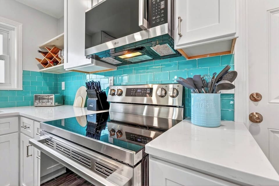 This gorgeous turquoise subway tile backsplash and stainless steel appliances make the kitchen feel both modern and incredibly inviting.