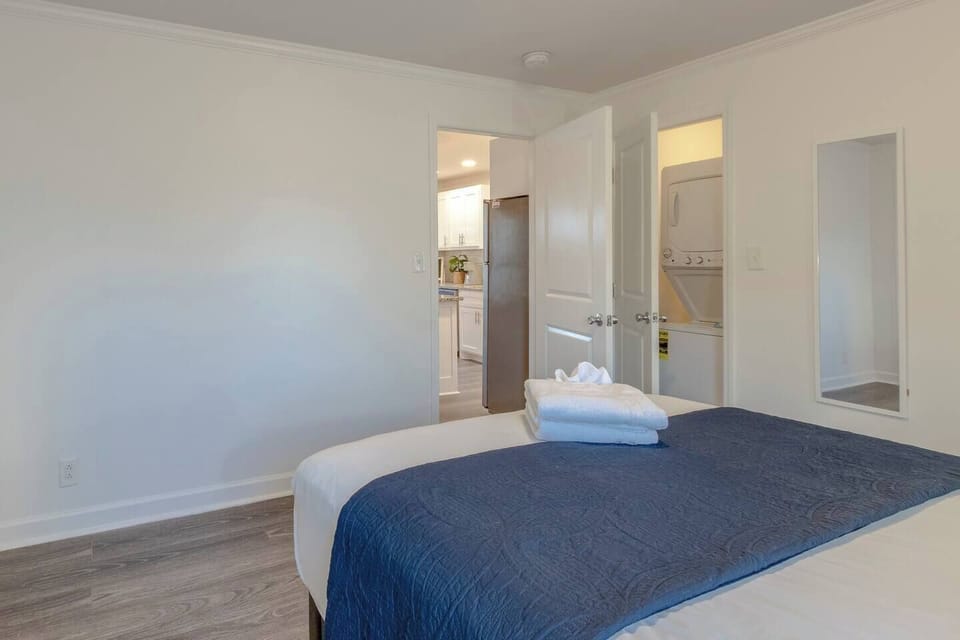 Bedroom with blue bedding and an open view toward the hallway