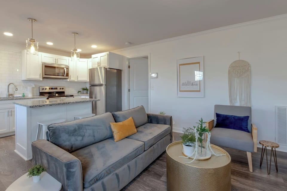 Living room featuring a gray sofa with yellow accent pillow and gold coffee table