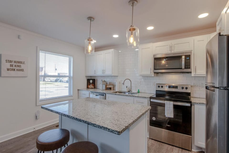 Kitchen with granite island, stainless range and refrigerator