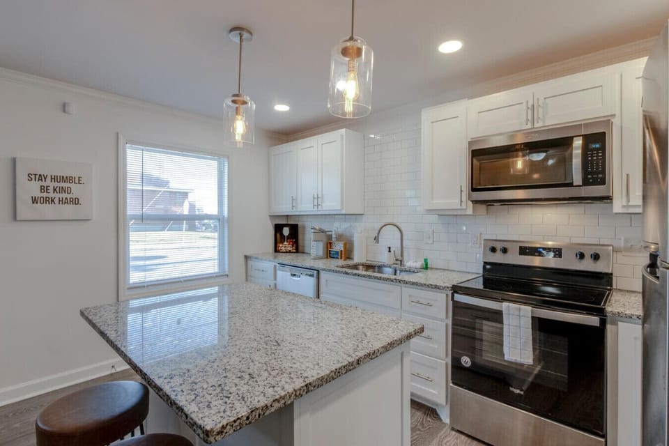 Kitchen with pendant lighting, granite counters and stainless range