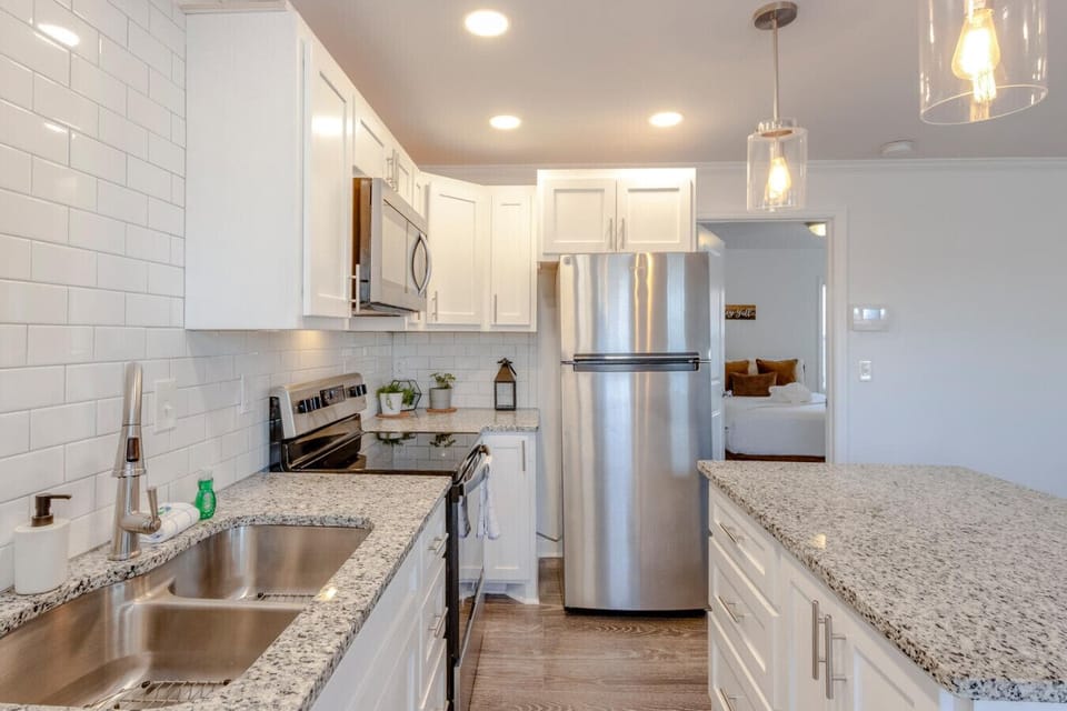 Kitchen with stainless refrigerator and white shaker cabinetry