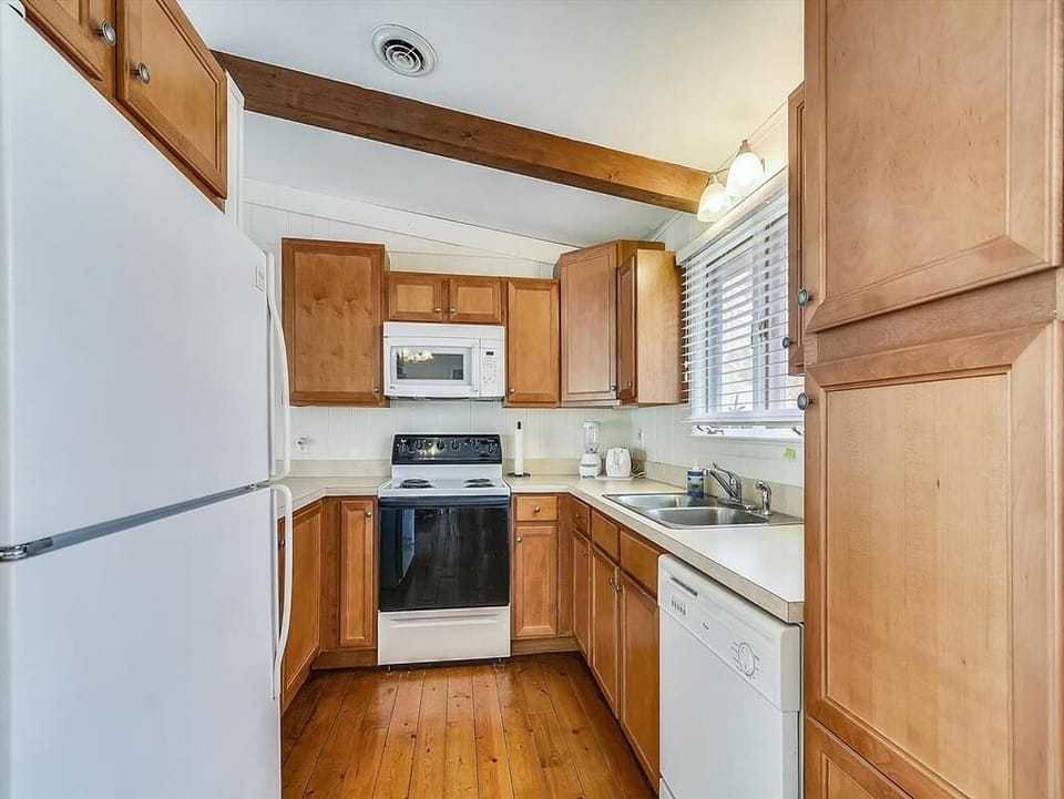 The cozy kitchen features warm wood cabinetry and modern appliances, creating an inviting space for family meals and gatherings.