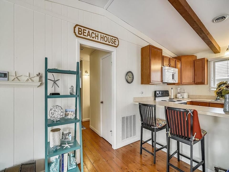 Entryway charm is emphasized with beach-themed décor, cozy seating, and easy access to the kitchen in this inviting family home.